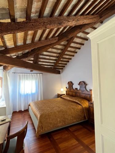 龐扎諾威尼托的住宿－Hotel Donna Lucia，一间卧室设有一张床和木制天花板