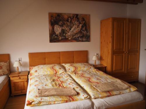 a bedroom with a bed with a painting on the wall at Privat Alenka in Liptovský Mikuláš