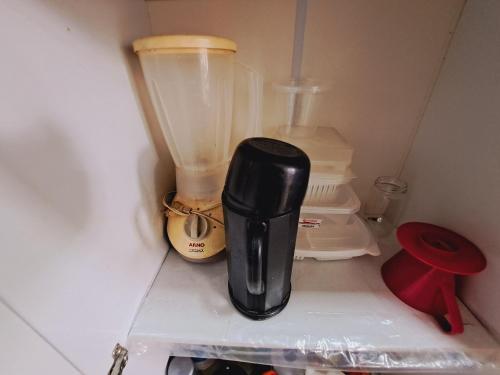 a black blender sitting on top of a refrigerator at Apto Completo com VAGA entre Botafogo e Copacabana in Rio de Janeiro
