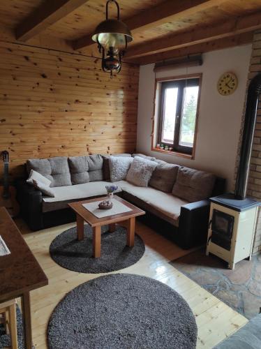 a living room with a couch and a table at Orange House in nature in Žabljak