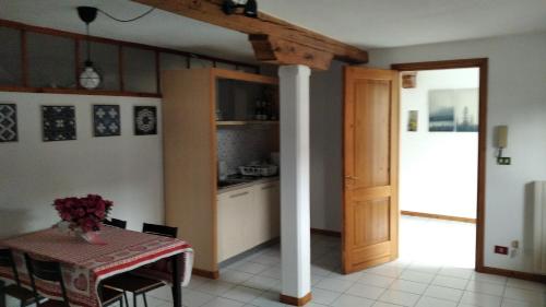 uma cozinha com uma mesa e uma coluna num quarto em Amnis em Aquileia