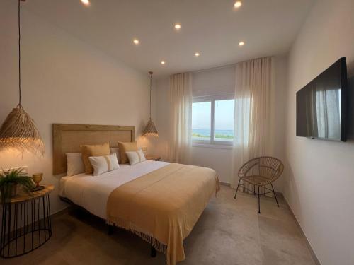 sypialnia z dużym łóżkiem i oknem w obiekcie Angeles Beach II by ELE Apartments w mieście Vélez-Málaga