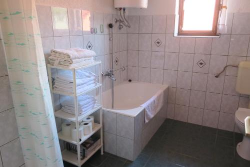 a bathroom with a tub and a sink and towels at Mesić Apartment in Senj