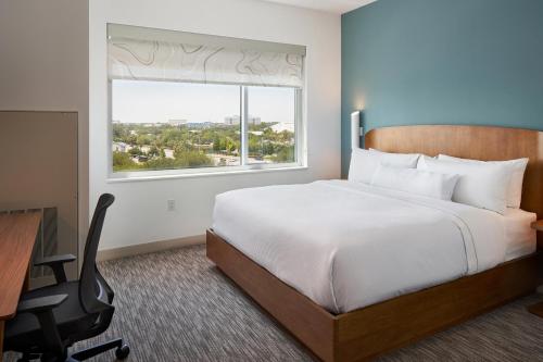 a bedroom with a bed and a desk and a window at Element by Westin Orlando International Drive in Orlando