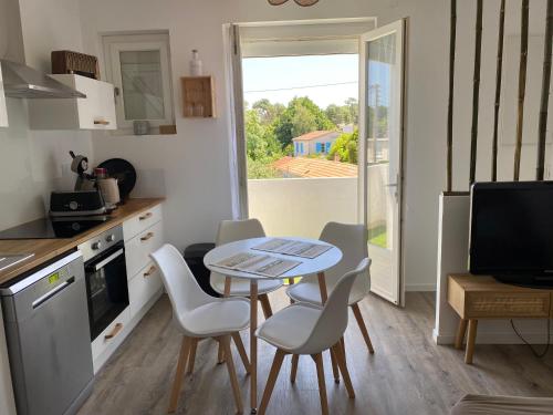 une petite cuisine avec une table et des chaises ainsi qu'une fenêtre dans l'établissement Appartement T2 Royan, à Royan
