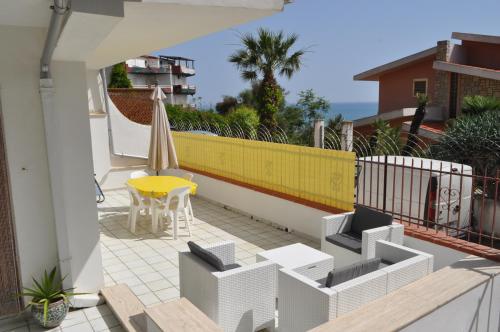 a balcony with a yellow table and a yellow umbrella at Casa Vacanze Sentilmare in Agrigento