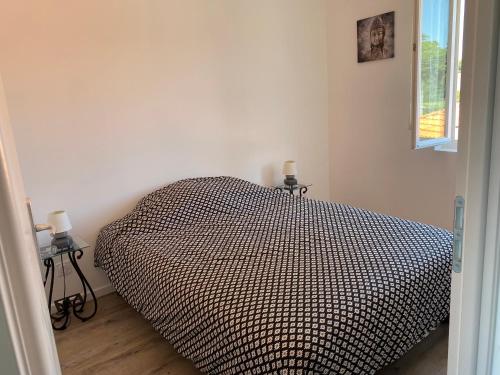 1 dormitorio con 1 cama con edredón blanco y negro en Appartement T2 Royan, en Royan