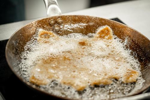 a pan with some food cooking in it at Hotel Post Andeer in Andeer