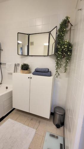 a white bathroom with a mirror and a sink at SeaCityView Oostende in Ostend
