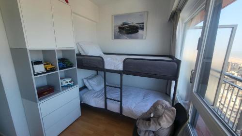 a small room with two bunk beds and a window at SeaCityView Oostende in Ostend