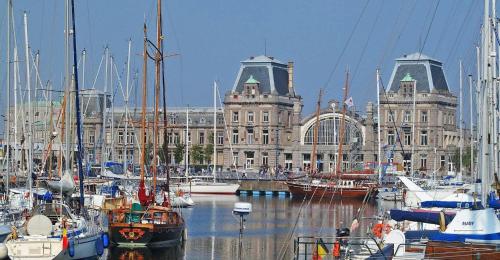 a group of boats in a marina in front of a building at SeaCityView Oostende in Ostend