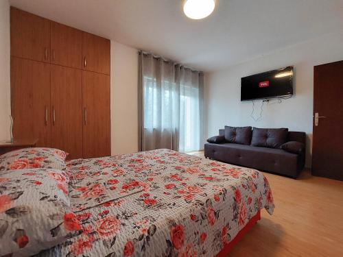 a bedroom with a bed and a couch and a television at Apartments Katica in Selce