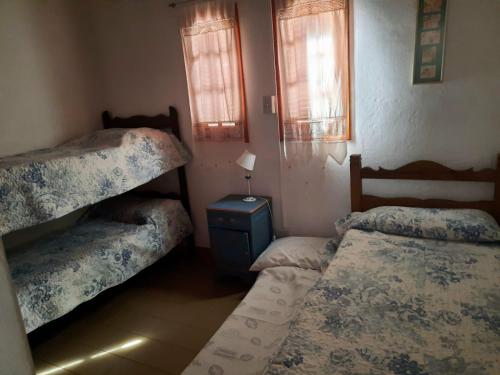 1 dormitorio con 2 literas y mesa en Casa Vacacional Salta Capital en Salta