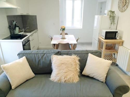 a living room with a gray couch with pillows at Le Cottage in Pamiers