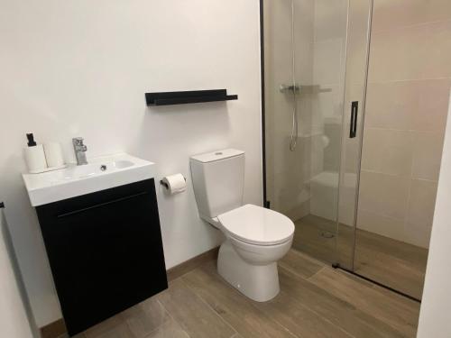 a bathroom with a toilet and a sink and a shower at Casa La via in Camarles