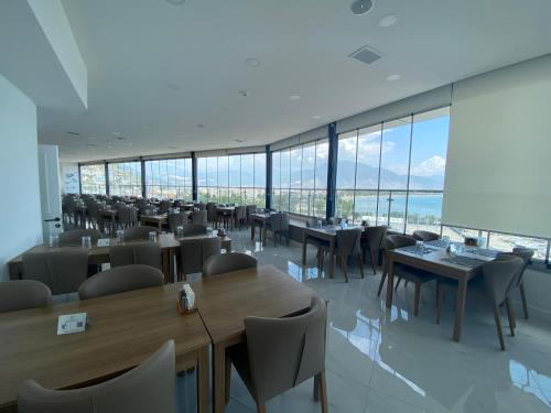 un ristorante con tavoli e sedie e grandi finestre di Finike Marina Hotel a Finike