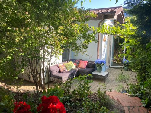 a patio with a couch in a garden at Romantic House -Romantyczny Domek dla 2 dorosłych in Gdynia