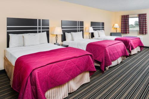 two beds in a hotel room with pink blankets at Soudersburg Inn & Suites Lancaster in Ronks