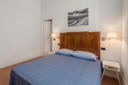 a bedroom with a blue bed with two pillows at Massarosa Front Lake, The Gargoyles in Massarosa