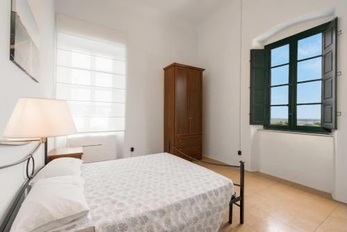 a white bedroom with a bed and a window at Massarosa Front Lake, The Gargoyles in Massarosa