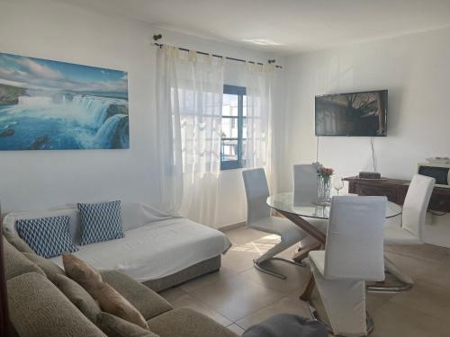 a living room with a couch and a table at Las Rosas Apartment (Adults Only) in Punta de Mujeres