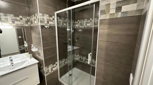 une salle de bain avec douche et lavabo dans l'établissement La Ruche 5 ° Le Mont Dore ° Ski ° Randonnée, à Le Mont-Dore