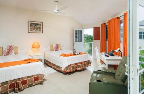 a hotel room with two beds and a chair at Rondel Village in Negril