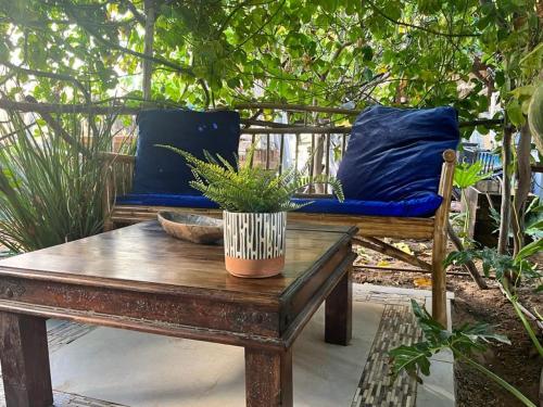 a wooden table with a bench and a blue pillow at Ahuzat Shaul Seaside in H̱adera