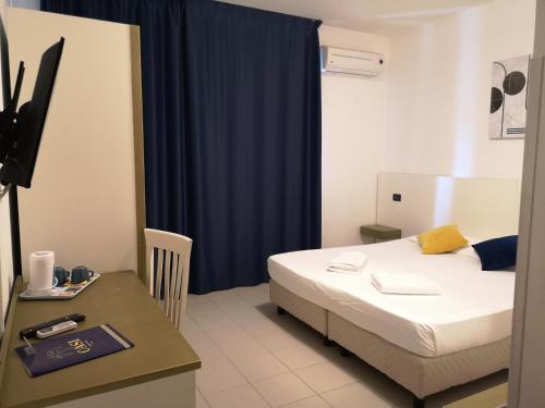 - une chambre avec un lit et un bureau avec un rideau bleu dans l'établissement Oasi Park Hotel, à Mascali
