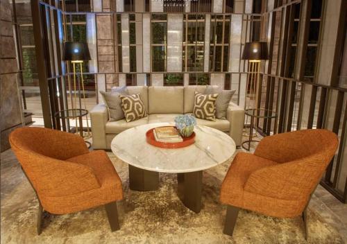 a living room with a couch and two chairs and a table at Apartemen springwood in Pakulonan Dua