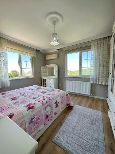 a bedroom with a bed and two windows at Country Home in Trabzon