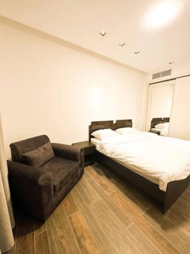 - une chambre avec un lit et une chaise dans l'établissement central apartment for rent 28, à Umm Uthainah