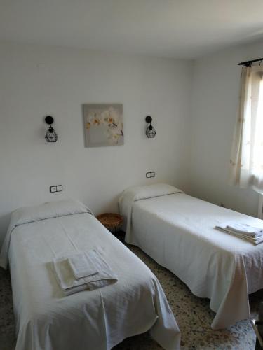 2 camas en una habitación con paredes blancas en Les oliveres de l'Empordà, en Bellcaire dʼEmpordà