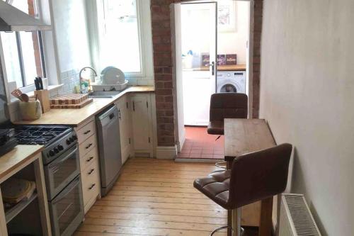 een keuken met een tafel en een fornuis top oven bij Lovely 3 bedroom house-Heart of Moseley Village in Birmingham