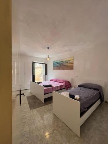 1 dormitorio con 2 camas y espejo en Totò’s house, en Zaccanopoli