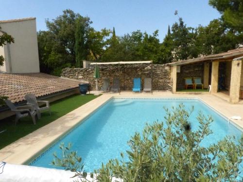 a large swimming pool in a yard with a house at La quiétude de St Antoine - piscine privée in LʼIsle-sur-la-Sorgue
