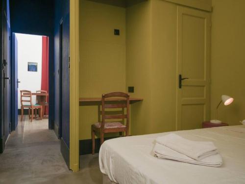 a bedroom with a bed and a table and chairs at maison Ravaux D in Arles