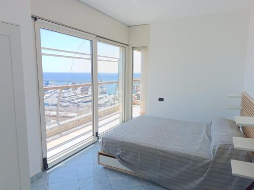 sypialnia z łóżkiem i widokiem na ocean w obiekcie Attico con Vista su Genova w Genui