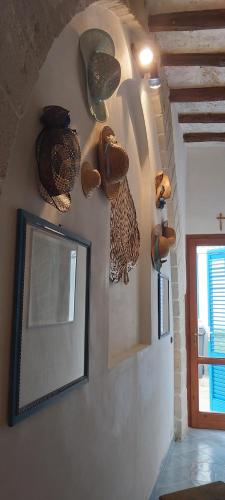 um quarto com uma parede com um espelho e algumas esculturas em La casetta di Giovanna em Marettimo