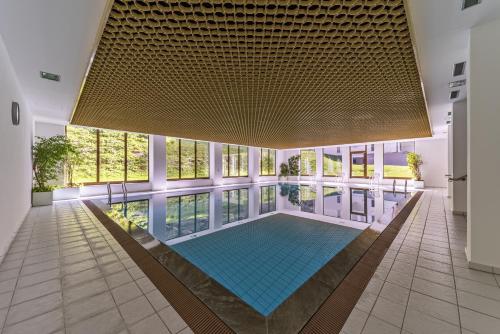 a large swimming pool in a building with a large ceiling at Chesa Guardaval - Surlej in Silvaplana