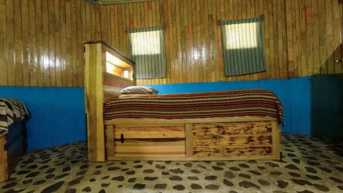 a bedroom with a wooden bed in a room at El Retiro Lanquin in Lanquín