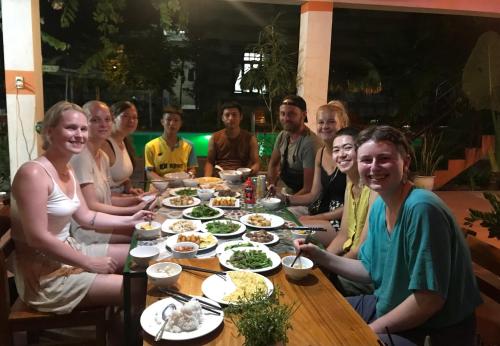 a group of people sitting around a table eating food at Phong Nha Dawn Home in Phong Nha