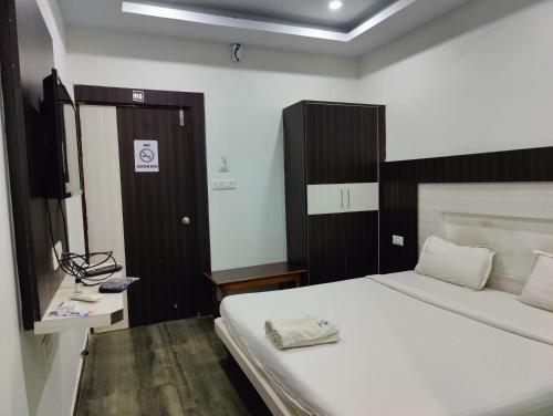 a bedroom with a bed and a wooden door at Hotel Cipron Inn in Udala