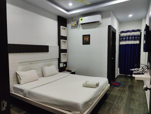 a bedroom with a white bed and a sink at Hotel Cipron Inn in Udala