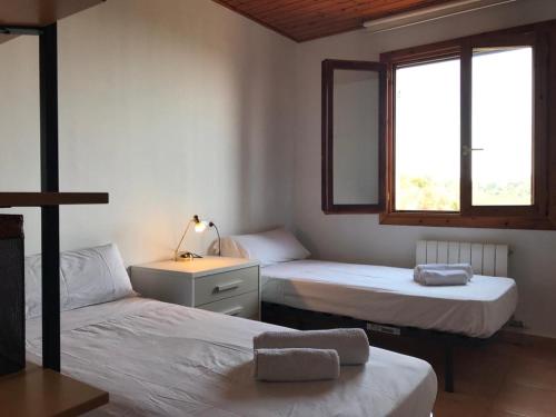 Sant Cebrià de VallaltaにあるCasa Mar y Piscina (solo familias)のベッドルーム1室(ベッド2台、デスク、窓2つ付)
