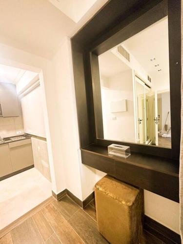 a bathroom with a large mirror and a stool at central apartment for rent 24 in Umm Uthainah
