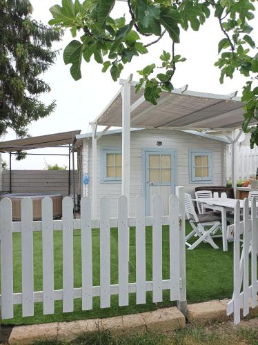 a white picket fence in front of a house at Casetta vista mare con piscina in Corsanico-Bargecchia