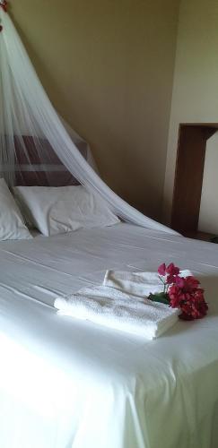 a white bed with towels and flowers on it at Village Lagoinha Ceará in Tigre