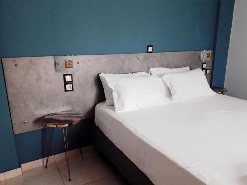 a hotel room with a bed and a stool next to it at Blue Waves Apartments in Plomarion