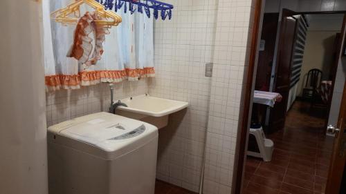 a bathroom with a washing machine and a sink at Amplio departamento en zona central norte 3B in Cochabamba